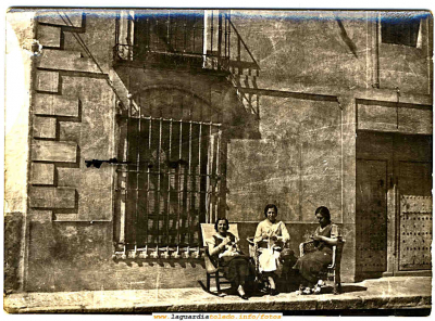 Las Boticarias cosiendo el la puerta de su casa
