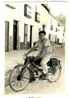 Manolito con una Guzi Hispania de 65 ?
Fijarse en el suelo de la calle Mayor y en las fachadas 

