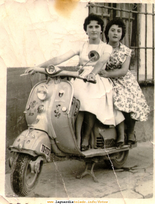 Dos amigas posando en una moto. Años 50
