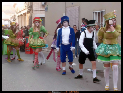 ¡¡ Juega conmigo !!, escena carnavalesca de la asociación "El Trajín". 25-2-12
"...Las abuelas cuando eran niñas tuvieron en sus manos una muñeca de trapo, ellas humildes con sus ojos de botones y sus articulaciones cosidas.
   Les acompañan sus amigas y amigos más elegantes, las muñecas y muñecos con ricos y finos vestidos y recargadas de puntillas, todas bailan de contentos porque dentro de un rato estarán en las manos de alguna niña o niño." (Texto extraído del folleto que repartía la muñeca sobre patines)
Palabras clave: el trajin carnaval 2012
