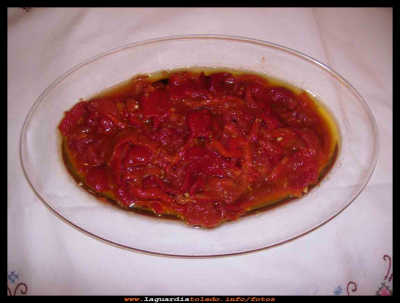  Asailla
La “asailla,”  junto con  el pisto, son los platos mas típicos en las fiestas de  La Guardia  para las cenas, pues se hacen las vísperas un pisto, o una “asailla” grande, y ya se tienen cenas para todos los días.
Ingredientes: 1 k de pimientos rojos y 2 tomates rojos. 
Los pimientos, y los tomates, se ponen en la bandeja del horno se les untan bien con aceite y se les echa una pizca de sal, se les mete al horno el tiempo que necesiten para que estén bien asados. Se sacan del horno, y se les deja enfriar  hasta que están templados (pues así se les pela mejor) ya pelados y cortados, se les hace una vinagreta, de aceite, vinagre, ajo muy picado, comino machacado y sal, moviendo todo bien. Se puede servir frio o templado.

Palabras clave: La “asailla,”  junto con  el pisto, son los platos mas típicos