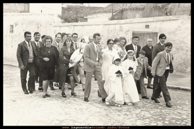 La carretera
Comunión de los hijos de Víctor y Petra, de camino a la iglesia, por la antigua carretera nacional, se ve  que la circulación que había en el año 1970 era escasa. Me parece que la puerta que se ve es la del tío “Casto” en donde tantos vehículos se metían al coger la curva.  

Palabras clave: La carretera en los años 70
